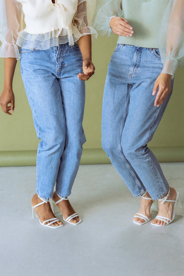 Photo of Women Wearing Denim Jeans and White Heels